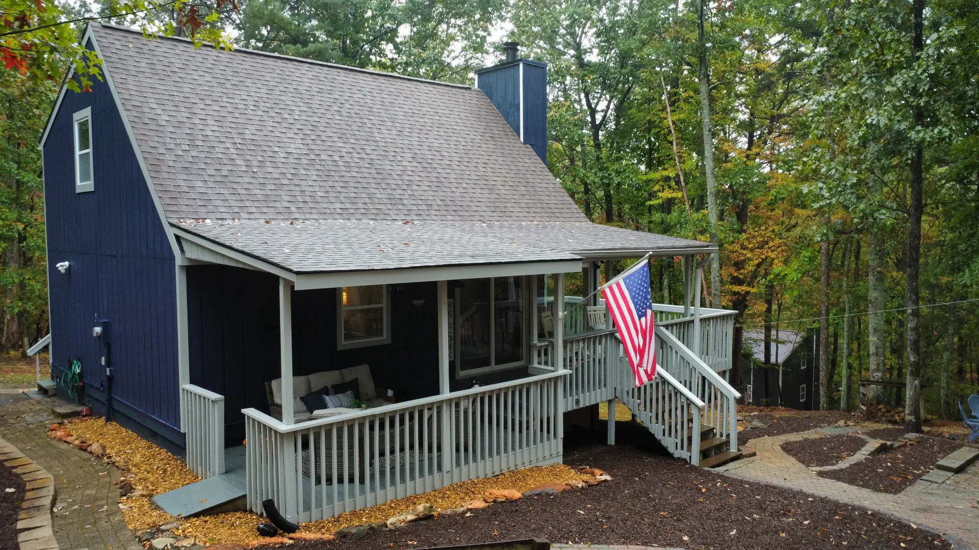 Elevated view of a dark blue cabin surrounded by trees