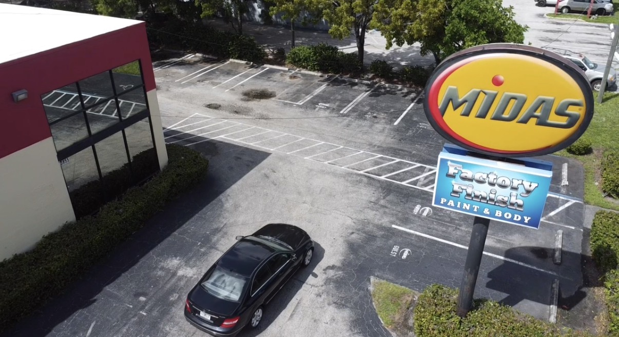 Aerial view of a Midas auto shop sign and parking lot