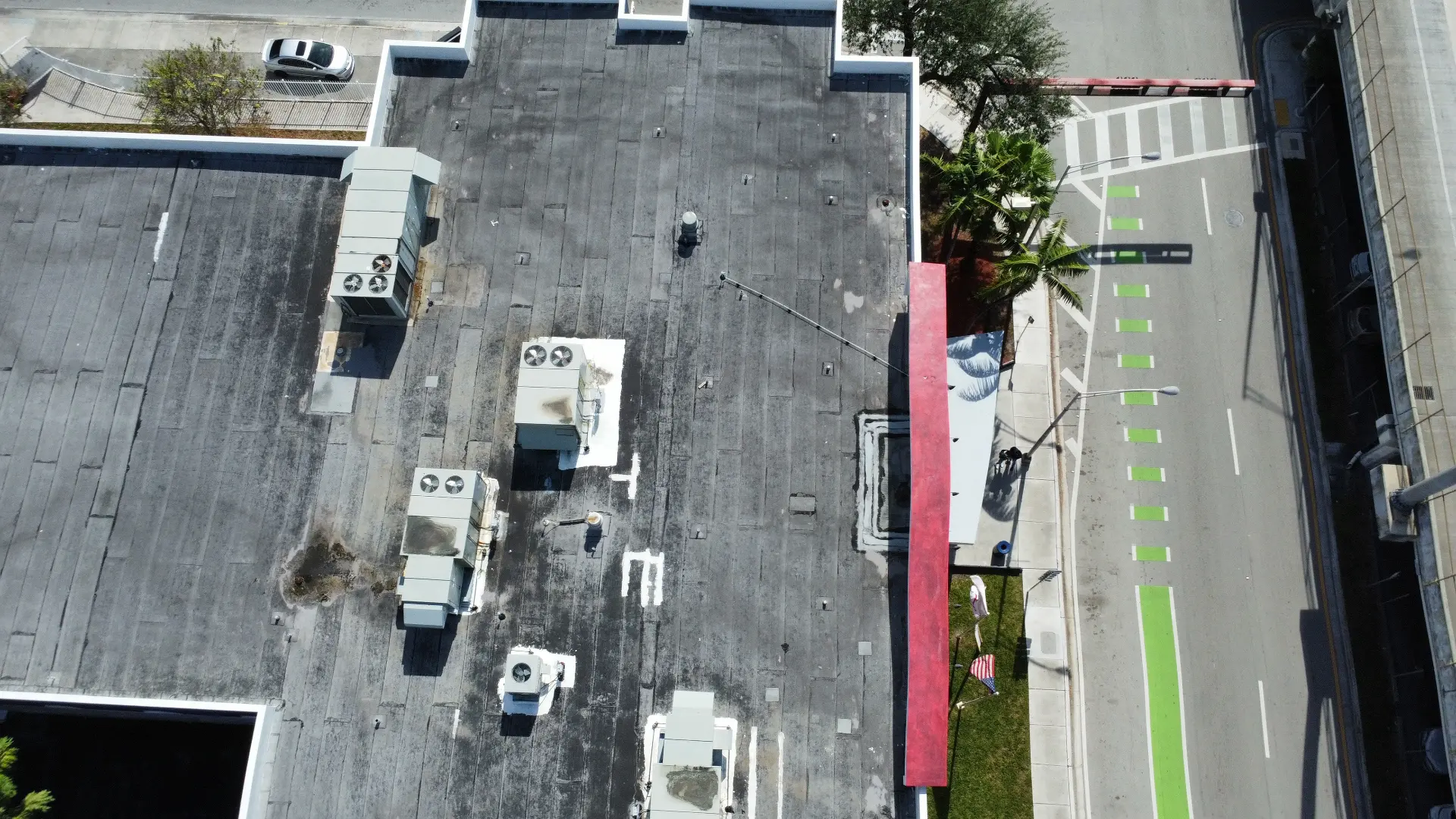 Top-down drone view of a downtown rooftop and street
